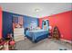 Fun bedroom featuring red and blue walls, a comfortable bed, and playful decor at 1007 Oak Marsh Ln., North Myrtle Beach, SC 29582