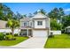 Charming two-story home featuring manicured lawn, inviting porch, and attached two-car garage at 1007 Oak Marsh Ln., North Myrtle Beach, SC 29582