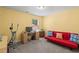 Comfortable office with yellow walls, ample sunlight, and a workspace complete with a desk and futon at 1007 Oak Marsh Ln., North Myrtle Beach, SC 29582