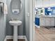 Charming powder room with a pedestal sink and a glimpse into the adjacent modern kitchen at 1007 Oak Marsh Ln., North Myrtle Beach, SC 29582