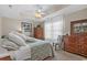Bedroom with tray ceiling, ceiling fan, warm neutral colors, dresser, and ample natural light at 1011 Sable Palm Way, Surfside Beach, SC 29575