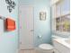 Bright bathroom featuring a toilet, window and door; peach-colored towels on rack at 106 Scotch Broom Dr. # 105, Little River, SC 29566