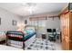 Comfortable bedroom features a metal frame bed, a computer desk, ceiling fan, and a cozy atmosphere with natural light at 106 Scotch Broom Dr. # 105, Little River, SC 29566