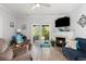 Comfortable living room with a fireplace, ceiling fan, and sliding glass door to the outside at 106 Scotch Broom Dr. # 105, Little River, SC 29566
