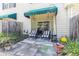 Charming patio area features outdoor seating with striped cushions, a small table, and a peaceful setting with greenery at 106 Scotch Broom Dr. # 105, Little River, SC 29566