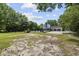 Large backyard with a partial view of a pool, green trees, and a swing set next to the driveway and garage at 109 Wofford Rd., Conway, SC 29526