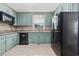 View of kitchen featuring light-green cabinets, granite countertops, and black appliances at 109 Wofford Rd., Conway, SC 29526