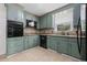 Cozy kitchen with green cabinets, tiled backsplash, granite countertops and black appliances at 109 Wofford Rd., Conway, SC 29526