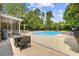 Outdoor pool with a fire table, surrounded by chairs, and mature trees at 109 Wofford Rd., Conway, SC 29526