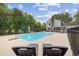 Backyard pool area featuring lounge chairs and diving board, surrounded by lush landscaping and a privacy fence at 109 Wofford Rd., Conway, SC 29526