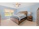 This bedroom features a wood frame bed, neutral carpeting, blue walls, and a window with backyard views at 1108 Donald St., Conway, SC 29527