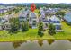 Aerial view of a neighborhood showcases a lake, trees, and manicured lawns at 1112 Whispering Winds Dr., Myrtle Beach, SC 29579