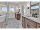 Bright bathroom boasts dual vanities, marble floors, soaking tub, and a large window with neighborhood views at 1112 Whispering Winds Dr., Myrtle Beach, SC 29579