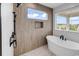 Primary bathroom features modern finishes including standalone tub with shower and large window at 1112 Whispering Winds Dr., Myrtle Beach, SC 29579