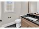 Charming powder room with a black granite countertop, hexagon tile flooring, and a decorative mirror at 1112 Whispering Winds Dr., Myrtle Beach, SC 29579