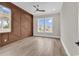 Sun-filled bedroom with wood-look tile flooring and a striking wood accent wall creating a stylish, modern aesthetic at 1112 Whispering Winds Dr., Myrtle Beach, SC 29579
