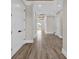 Bright hallway with wood-look tile flooring, white trim, and natural light streaming through the outdoor deck at 1112 Whispering Winds Dr., Myrtle Beach, SC 29579