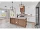 Gourmet kitchen island features a built-in sink, a stainless-steel refrigerator, and pendant lighting at 1112 Whispering Winds Dr., Myrtle Beach, SC 29579