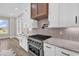 This kitchen features stainless steel appliances, sleek white cabinets, and a stylish range hood at 1112 Whispering Winds Dr., Myrtle Beach, SC 29579