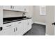 Laundry room with sleek black countertop, modern cabinetry, and a dark tiled floor at 1112 Whispering Winds Dr., Myrtle Beach, SC 29579