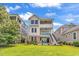Beautiful two-story home with a well-manicured lawn, brick accents, and multiple balconies at 1112 Whispering Winds Dr., Myrtle Beach, SC 29579
