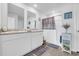 Bright bathroom with double sinks, modern fixtures, a shower, and wood-look floors, offering a clean and functional space at 113 Arbor Crest Ln., Tabor City, NC 28463