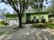 Modern home featuring a light green exterior, clean lines, a front-entry garage, and professional landscaping at 116 Capt Anthony White Ln., Georgetown, SC 29440