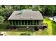 Aerial view shows the rear exterior of the home with a screened-in porch and lush green landscaping at 116 Capt Anthony White Ln., Georgetown, SC 29440