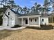 Charming single story home featuring a covered front porch, a two-car garage, and professionally landscaped yard at 118 Goodson Loop, Pawleys Island, SC 29585