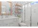 Well-lit bathroom with decorative wallpaper, vanity with storage, and shower with glass door at 1415 Powhaton Dr., Myrtle Beach, SC 29577