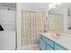 Cozy bathroom with a blue vanity, floral shower curtain, and a convenient washer and dryer unit at 1415 Powhaton Dr., Myrtle Beach, SC 29577