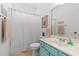 A functional bathroom showcasing a turquoise vanity, toilet, shower with curtain, and decor at 1415 Powhaton Dr., Myrtle Beach, SC 29577