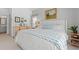Bright main bedroom features tasteful decor, a patterned quilt, and an ensuite bathroom at 1415 Powhaton Dr., Myrtle Beach, SC 29577