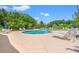 Community swimming pool featuring several lounge chairs, umbrellas and mature trees at 1415 Powhaton Dr., Myrtle Beach, SC 29577