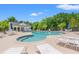 Community swimming pool featuring several lounge chairs, umbrellas, and pool house at 1415 Powhaton Dr., Myrtle Beach, SC 29577