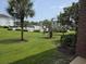 Green lush lawn with palm trees and a fenced pool in the distance on a sunny day at 1514 Lanterns Rest Dr. # 103, Myrtle Beach, SC 29579