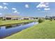Backyard view showcases the canal, green lawn, and the backs of several houses at 1725 Boyne Dr., Myrtle Beach, SC 29588