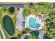 An aerial view showcases a community pool, ample parking, a beautiful pond, and lush trees at 1788 Club Circle, Pawleys Island, SC 29585