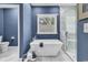 Modern bathroom featuring a standalone tub, walk-in shower, and stylish blue walls at 1788 Club Circle, Pawleys Island, SC 29585