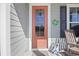Charming front door adorned with seasonal decor, complemented by a rocking chair on a welcoming porch at 1838 Zodiac Court, Myrtle Beach, SC 29577