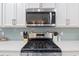Stainless steel stove and microwave with backsplash, white cabinets, and quartz countertops at 1838 Zodiac Court, Myrtle Beach, SC 29577
