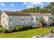 Exterior shot of condo with manicured lawn, mature trees, and clear blue skies at 1931 Bent Grass Dr. # H, Surfside Beach, SC 29575