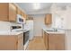 Well-lit kitchen featuring wood cabinets, white appliances, and tiled floors at 1931 Bent Grass Dr. # H, Surfside Beach, SC 29575