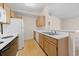 Functional kitchen showcasing wood cabinets, white appliances, and a breakfast bar for casual dining at 1931 Bent Grass Dr. # H, Surfside Beach, SC 29575
