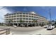 Multi-story condo building featuring numerous balconies, ground level parking, and palm trees on street front at 200 53Rd Ave. N # 205, North Myrtle Beach, SC 29582