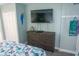 Relaxing bedroom features a flatscreen TV, wooden dresser, and a parrot decoration at 2001 S Ocean Blvd. S # 1013, Myrtle Beach, SC 29577