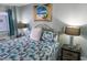Cozy bedroom features a coastal-themed bed and a charming seaside painting for a tranquil retreat at 2001 S Ocean Blvd. S # 1013, Myrtle Beach, SC 29577