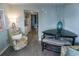 Comfortable living room with table, vase, floral chair, kitchen, and bedroom views at 2001 S Ocean Blvd. S # 1013, Myrtle Beach, SC 29577