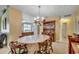 Cozy dining area featuring a chandelier, wooden table, and built-in china cabinet adjacent to kitchen at 220 Gateway Dr., Little River, SC 29566