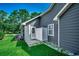Home exterior featuring tidy landscaping, an outdoor shower, and neutral gray siding at 220 Gateway Dr., Little River, SC 29566